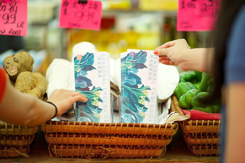 Two hands reaching for a Choi Guide at a supermarket